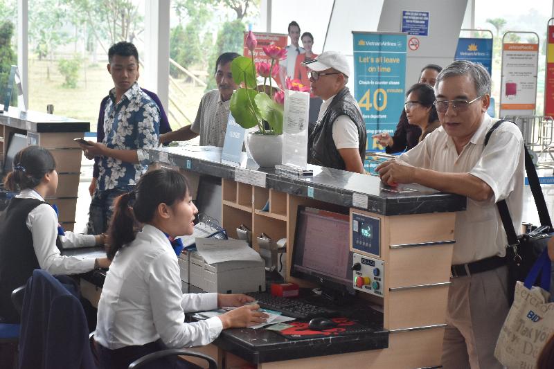 Hình ảnh một người đang xem đồng hồ hoặc điện thoại ở sân bay hoặc tại một điểm du lịch ở Hàn Quốc, với vali bên cạnh, minh họa việc quản lý thời gian khi du lịch/công tác.